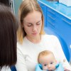 Kleinkund auf dem Schoß der Mutter auf dem Zahnarztstuhl