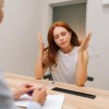 Patientin hebt frustriert Arme neben den Kopf