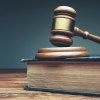 Gavel (Richterhammer) liegt auf Resonanzblock, darunter ein Buch