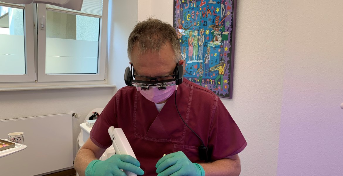 Zahnarzt mit intraoral Scanner und Patientin in Praxis