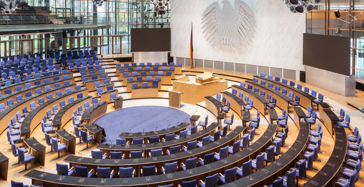 großer Plenarsaal mit Bundesadler an der Wand