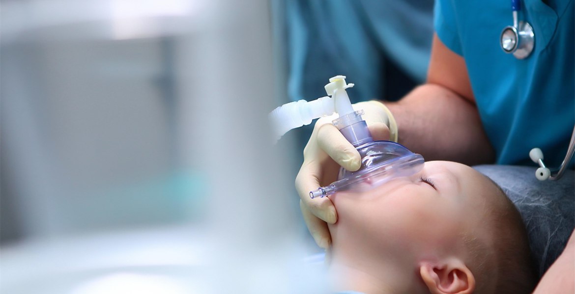 kleiner Junge schlafend mit Anästhesiemaske vor dem Gesicht
