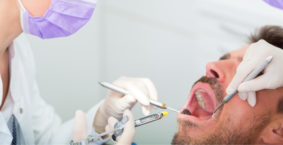 Behandlungssituation beim Zahnarzt mit Mann mit geöffnetem Mund