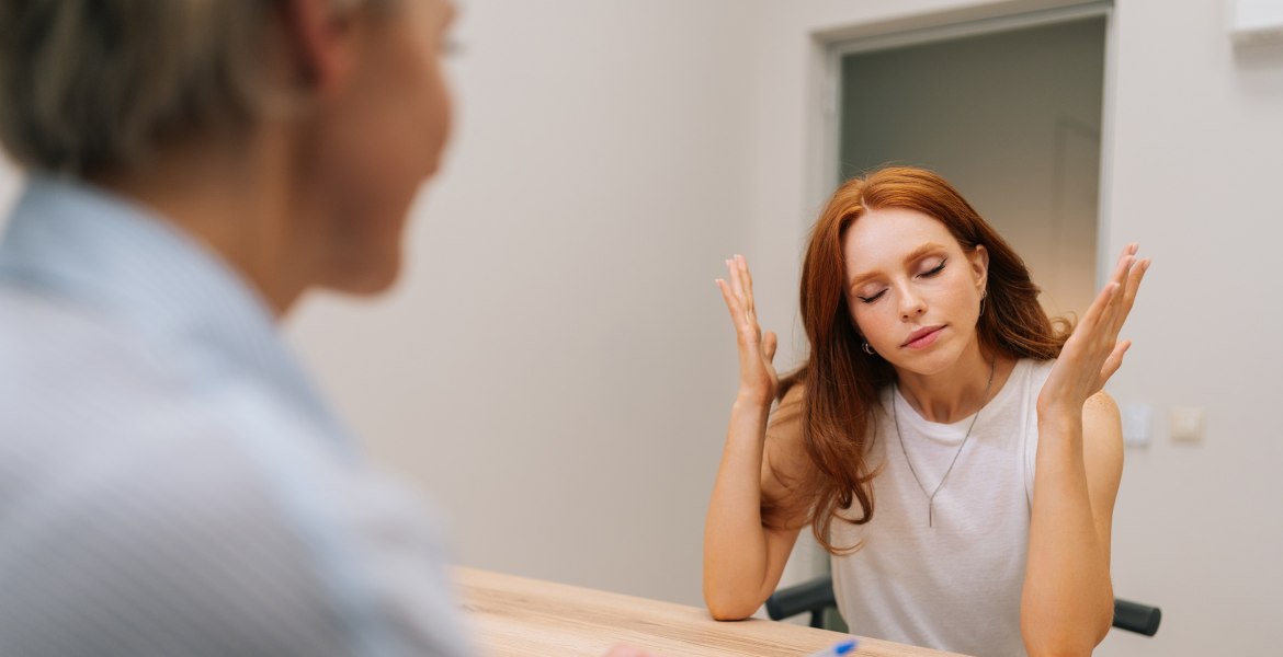 Patientin hebt frustriert Arme neben den Kopf