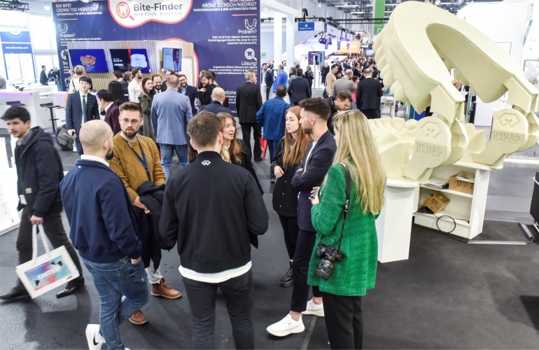 Gruppe von jungen Menschen im Kreis stehend in einer vollen IDS-Messehalle
