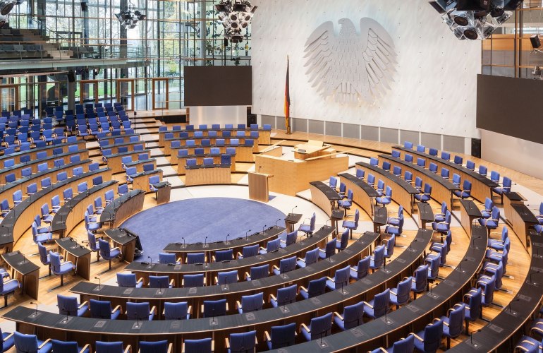 großer Plenarsaal mit Bundesadler an der Wand