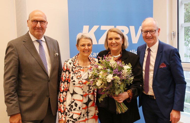 zwei Männer und zwei Frauen stehen nebeneinander vor einem KZBV-Schild
