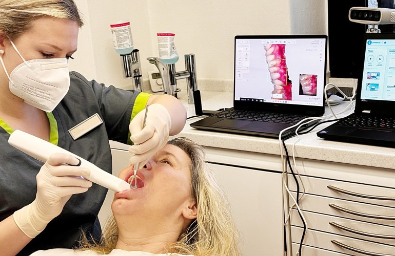 Frau mit Intraoralsscanner mit einer Patientin