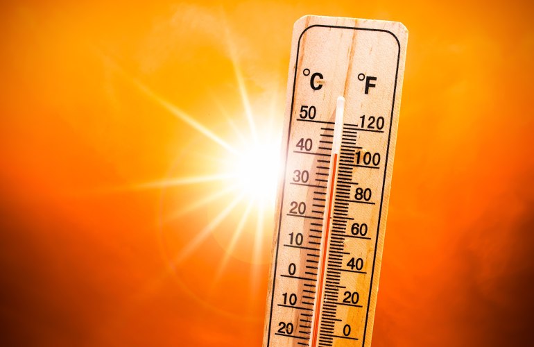 Thermometer zeigt über 40 Grad Celsius an, im Hintergrund grell die Sonne